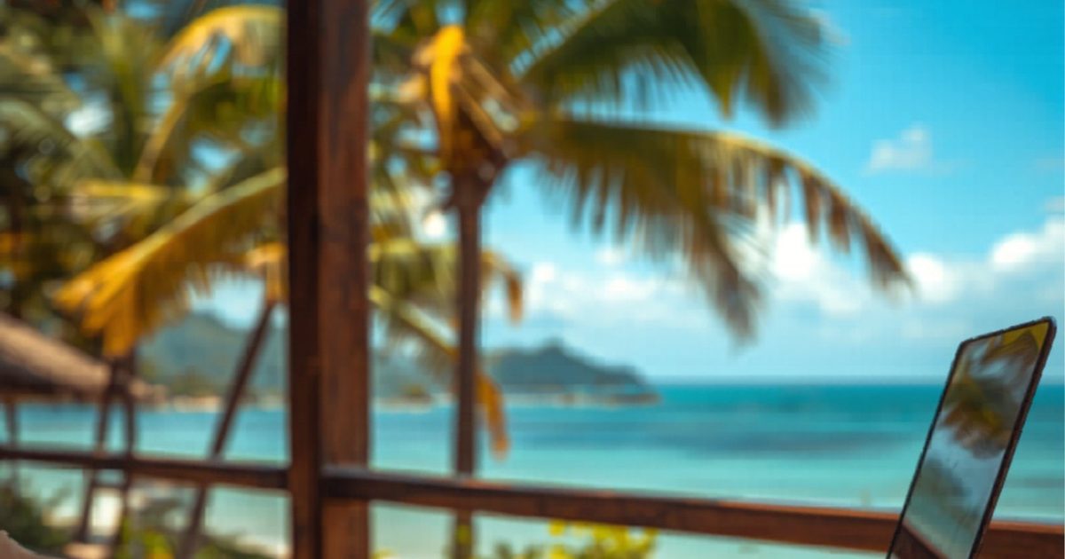 Digital nomad working on laptop at tropical beachside cafe in Phu Quoc